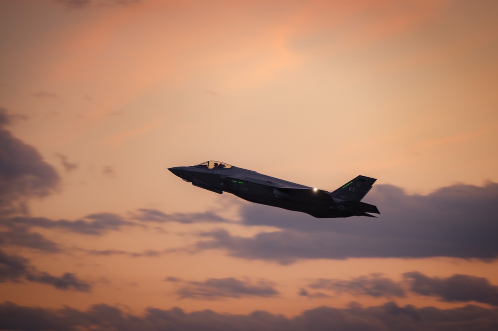 F-35A Lightning II fighter jet flying at dusk